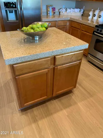 a kitchen with granite countertop a stove and a wooden floor