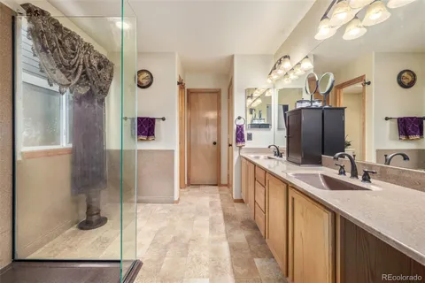 a bathroom with a double vanity sink mirror and shower