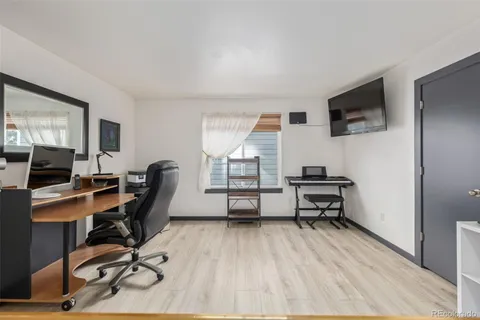 a view of a workspace with furniture and a window