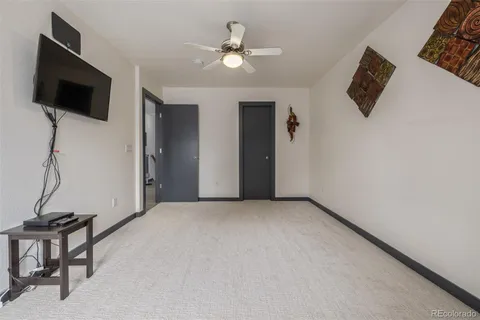 a view of room with flat screen tv and a ceiling fan
