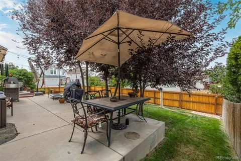 a backyard of a house with table and chairs