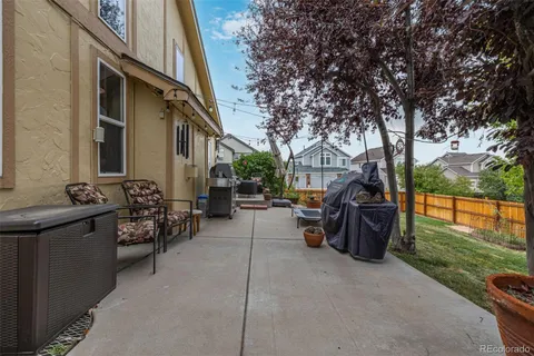 a view of a patio with table and chairs and couches with wooden fence and floor