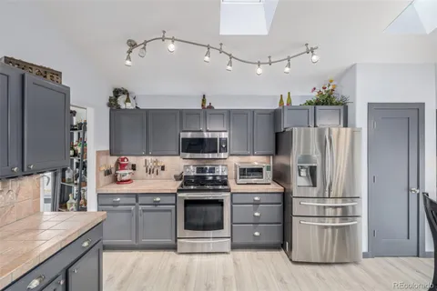 a kitchen with stainless steel appliances a stove a refrigerator and cabinets