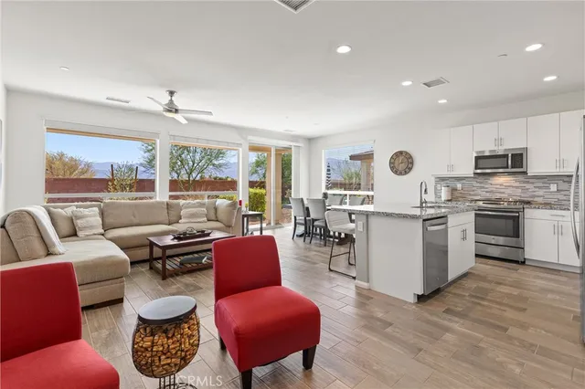 a living room with furniture a large window and a chandelier
