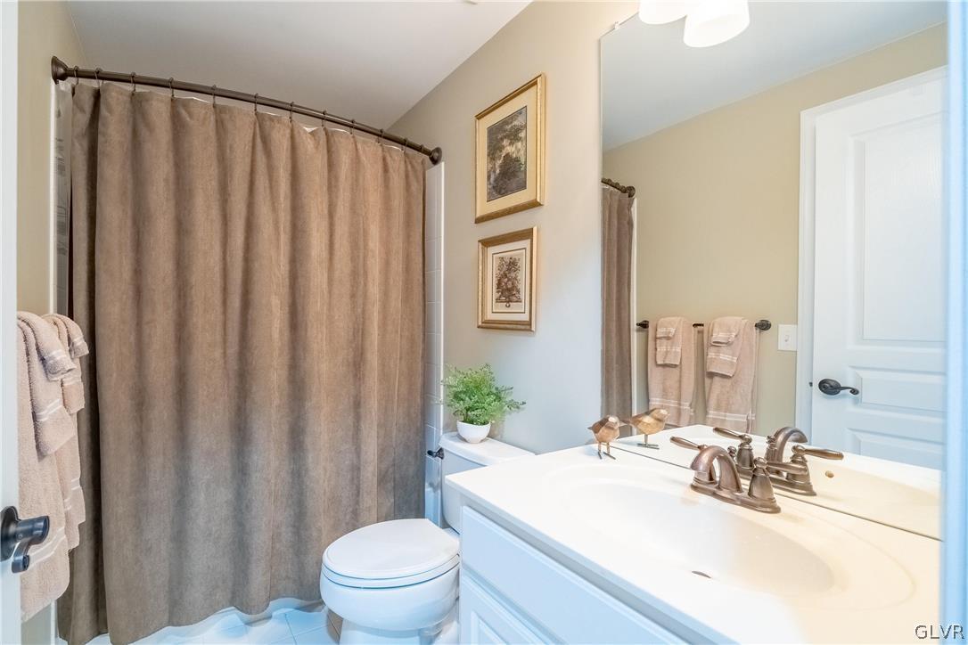 2296 Eldemere Circle Lower Macungie Township, PA 18062 - Photo 40 of 50 a bathroom with a sink a toilet a mirror and shower curtain