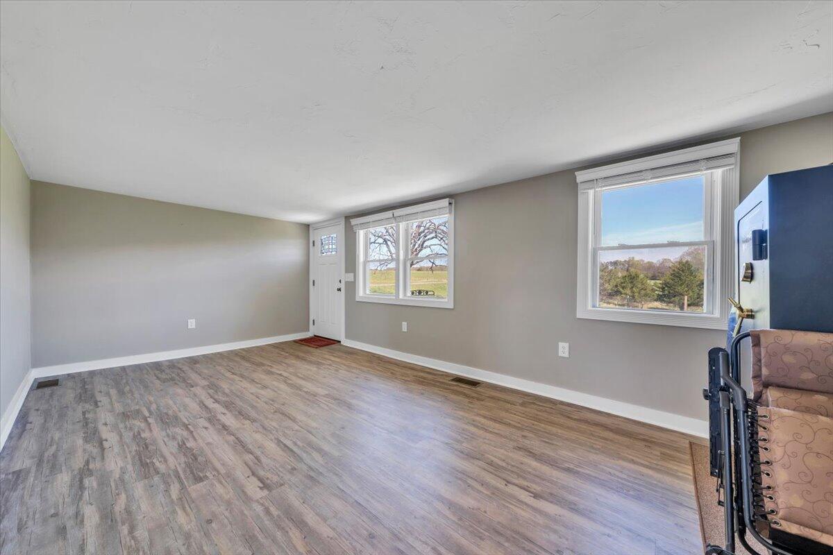 3861 Wheatland Road Bedford, VA 24523 - Photo 20 of 99 an empty room with wooden floor and windows