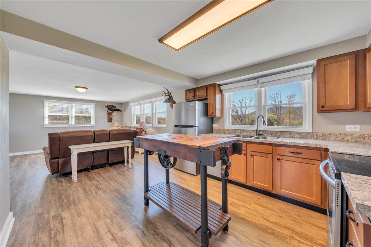 3861 Wheatland Road Bedford, VA 24523 - Photo 29 of 99 a kitchen with stainless steel appliances granite countertop a stove a sink dishwasher and a dining table with wooden floor
