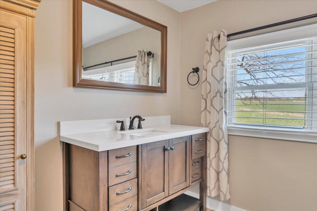 3861 Wheatland Road Bedford, VA 24523 - Photo 39 of 99 a bathroom with a sink a mirror a vanity and a window