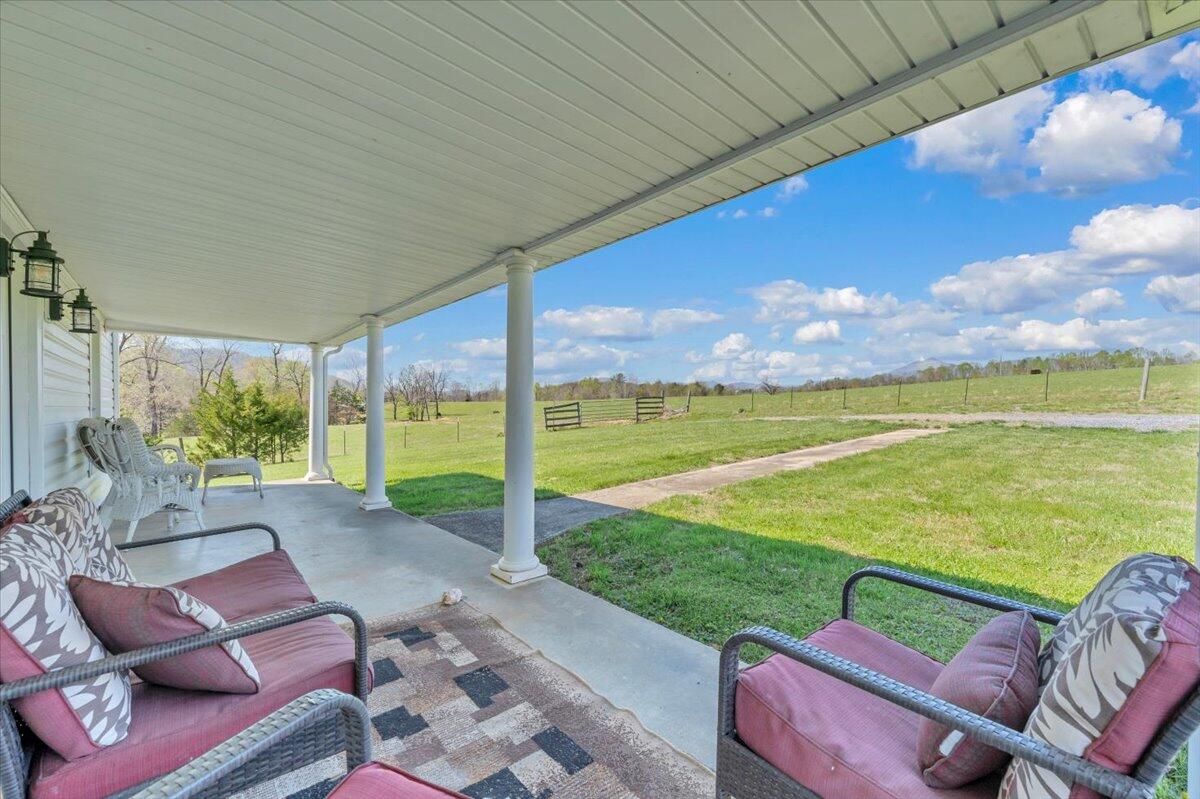 3861 Wheatland Road Bedford, VA 24523 - Photo 10 of 99 a view of a patio with lawn chairs under an umbrella
