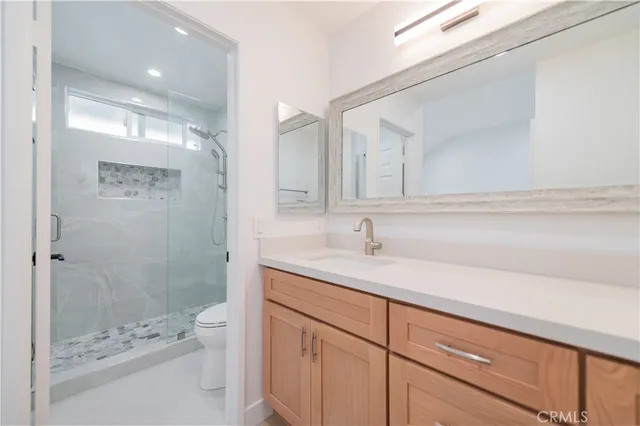 a bathroom with a sink a toilet and shower