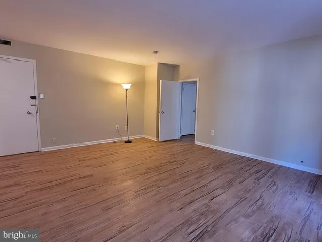 a view of an empty room and wooden floor