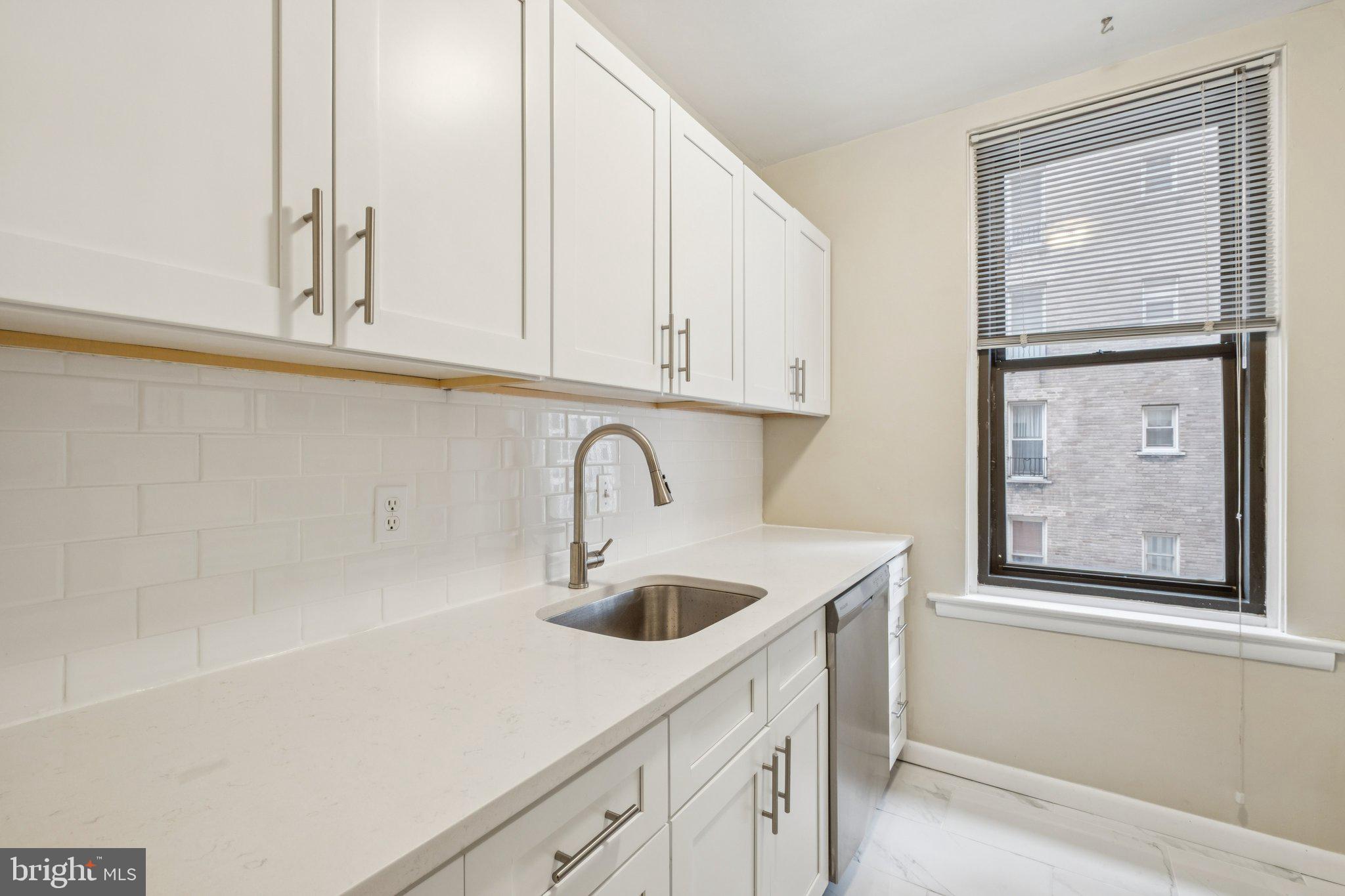 135 South 19th Street, Unit 908 Philadelphia, PA 19103 - Photo 6 of 18 a kitchen with stainless steel appliances granite countertop a sink and a white cabinets with wooden floor