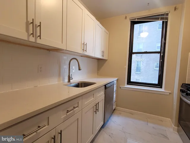 a kitchen with stainless steel appliances granite countertop a sink and dishwasher with white cabinets