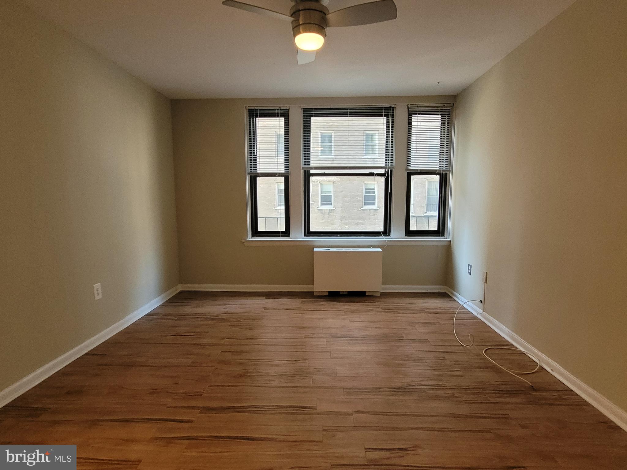 135 South 19th Street, Unit 908 Philadelphia, PA 19103 - Photo 9 of 20 an empty room with wooden floor and windows