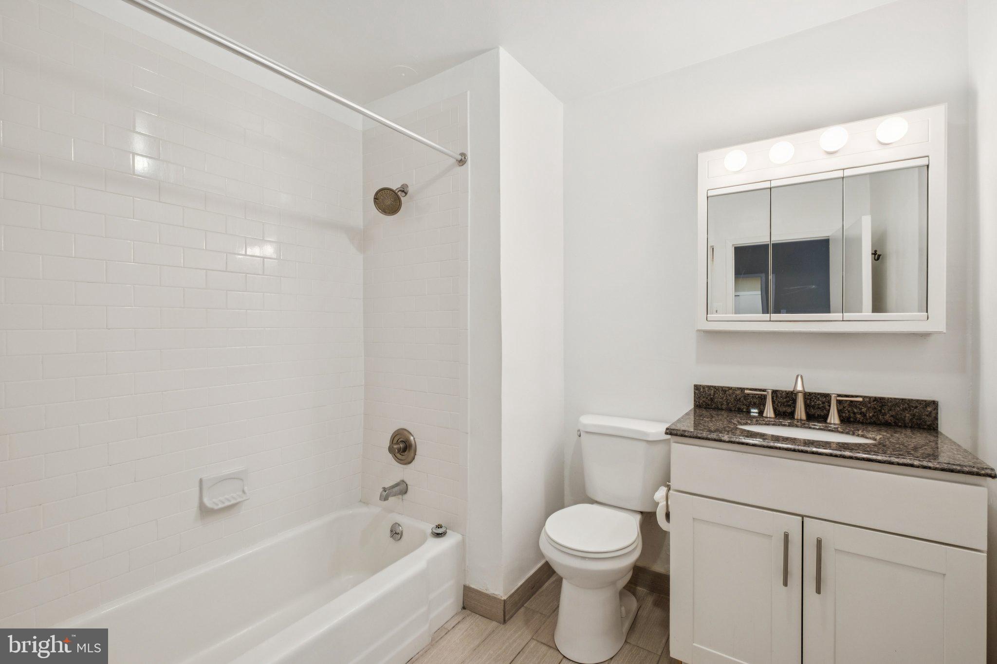 135 South 19th Street, Unit 908 Philadelphia, PA 19103 - Photo 10 of 18 a bathroom with a bathtub shower sink vanity and toilet