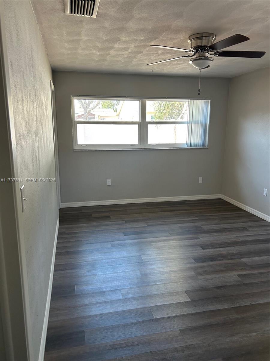 7403 Foxbloom Drive Port Richey, FL 34668 - Photo 28 of 45 a view of an empty room with wooden floor and a window