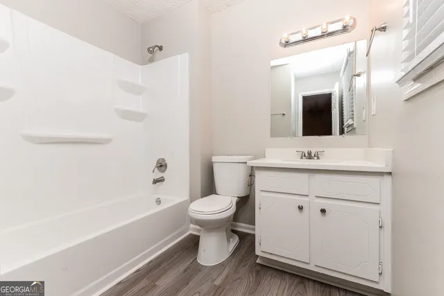 a bathroom with a sink toilet a mirror and shower