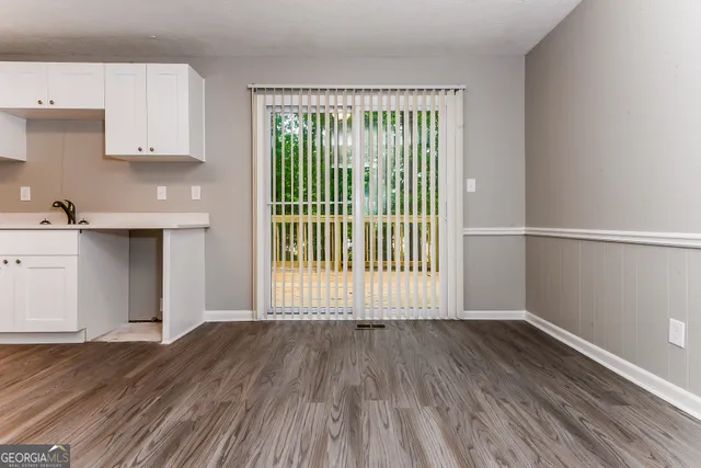 a view of a kitchen with wooden floor and a window