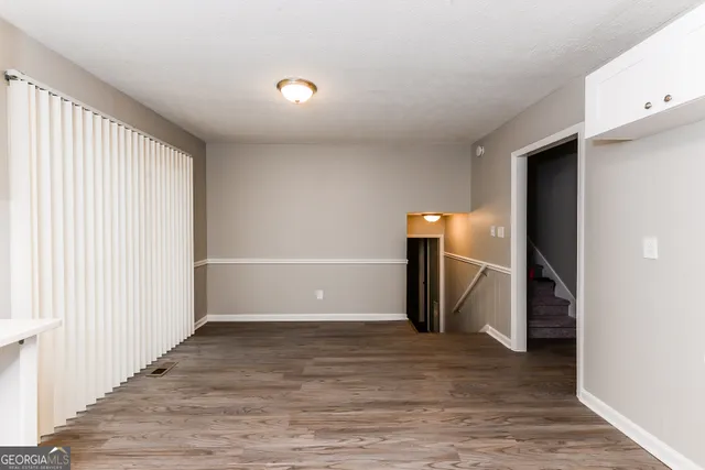 a view of a livingroom with wooden floor and staircase