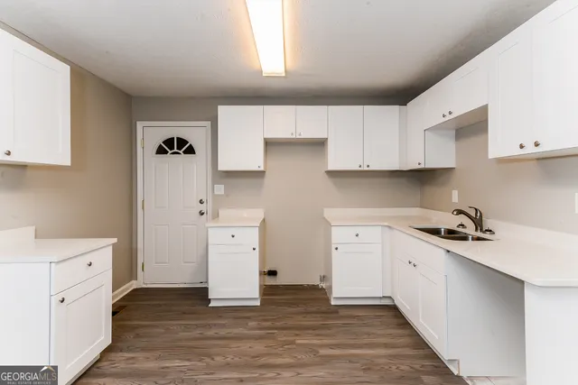 a kitchen with white cabinets and white appliances
