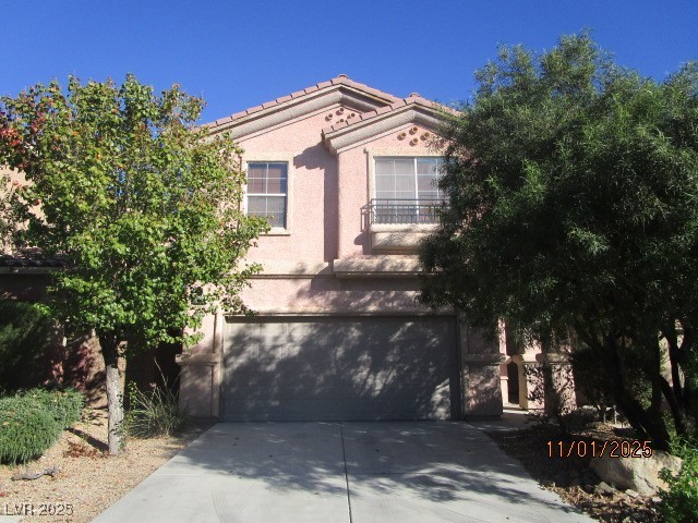 Mediterranean / spanish-style home with an attached garage, stucco siding, and concrete driveway