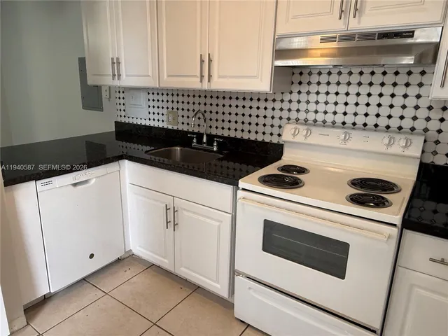 a kitchen with a stove and white cabinets