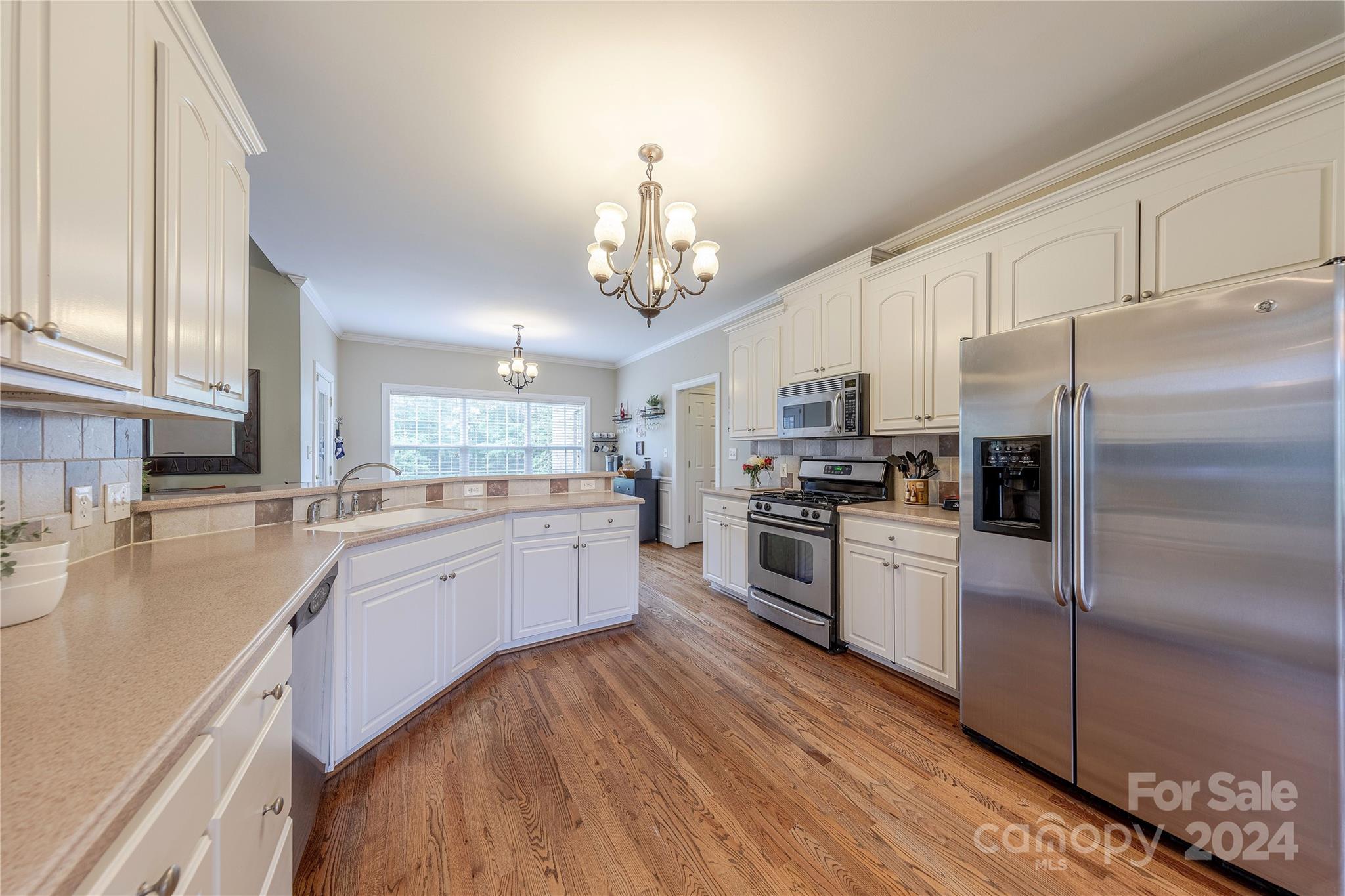 3321 Millstone Creek Road Lancaster, SC 29720 - Photo 18 of 48 a large kitchen with granite countertop a refrigerator oven a sink dishwasher and white cabinets with wooden floor