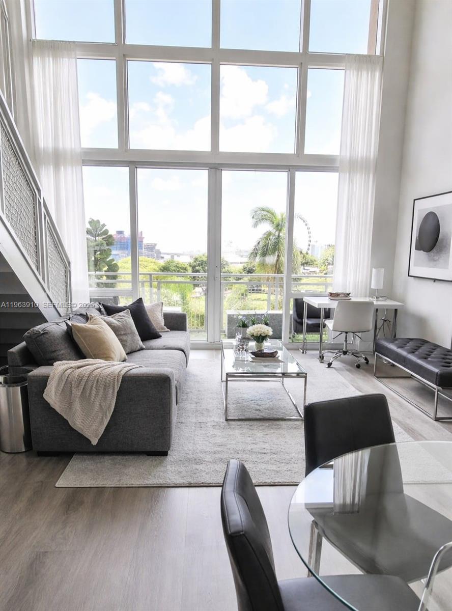 a living room with couches and a large window with garden view