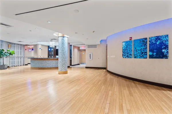 a living room with stainless steel appliances lots of furniture and wooden floor