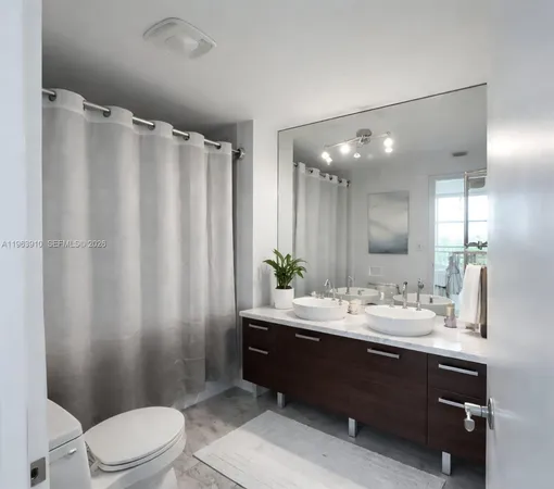 a bathroom with a double vanity sink toilet and a mirror