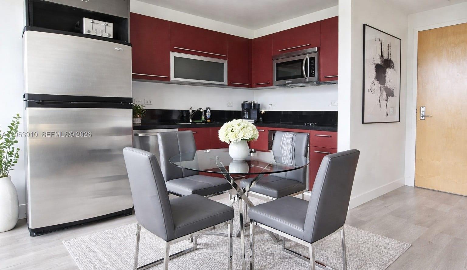 253 Northeast 2nd Street, Unit 433 Miami, FL 33132 - Photo 6 of 32 a kitchen with stainless steel appliances kitchen island granite countertop furniture and a refrigerator