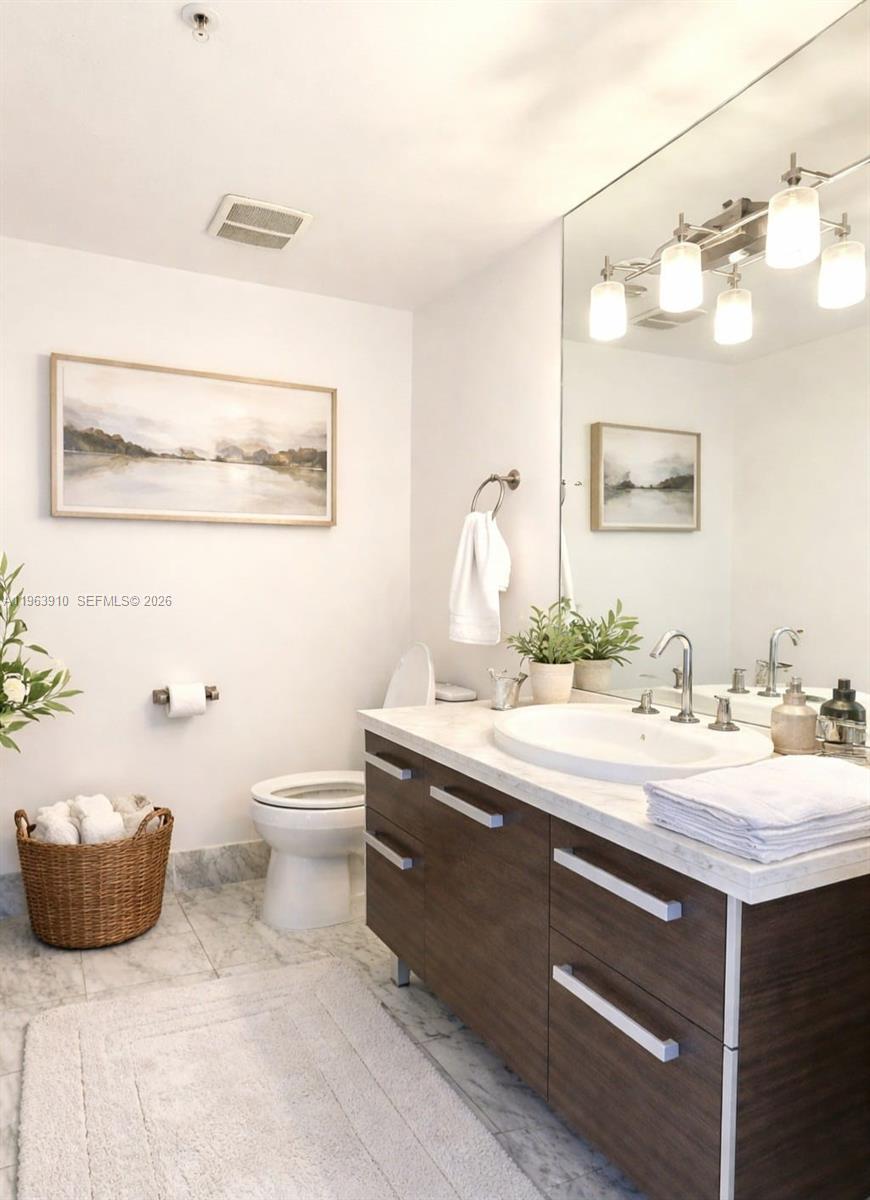 253 Northeast 2nd Street, Unit 433 Miami, FL 33132 - Photo 7 of 32 a bathroom with a granite countertop sink and a mirror