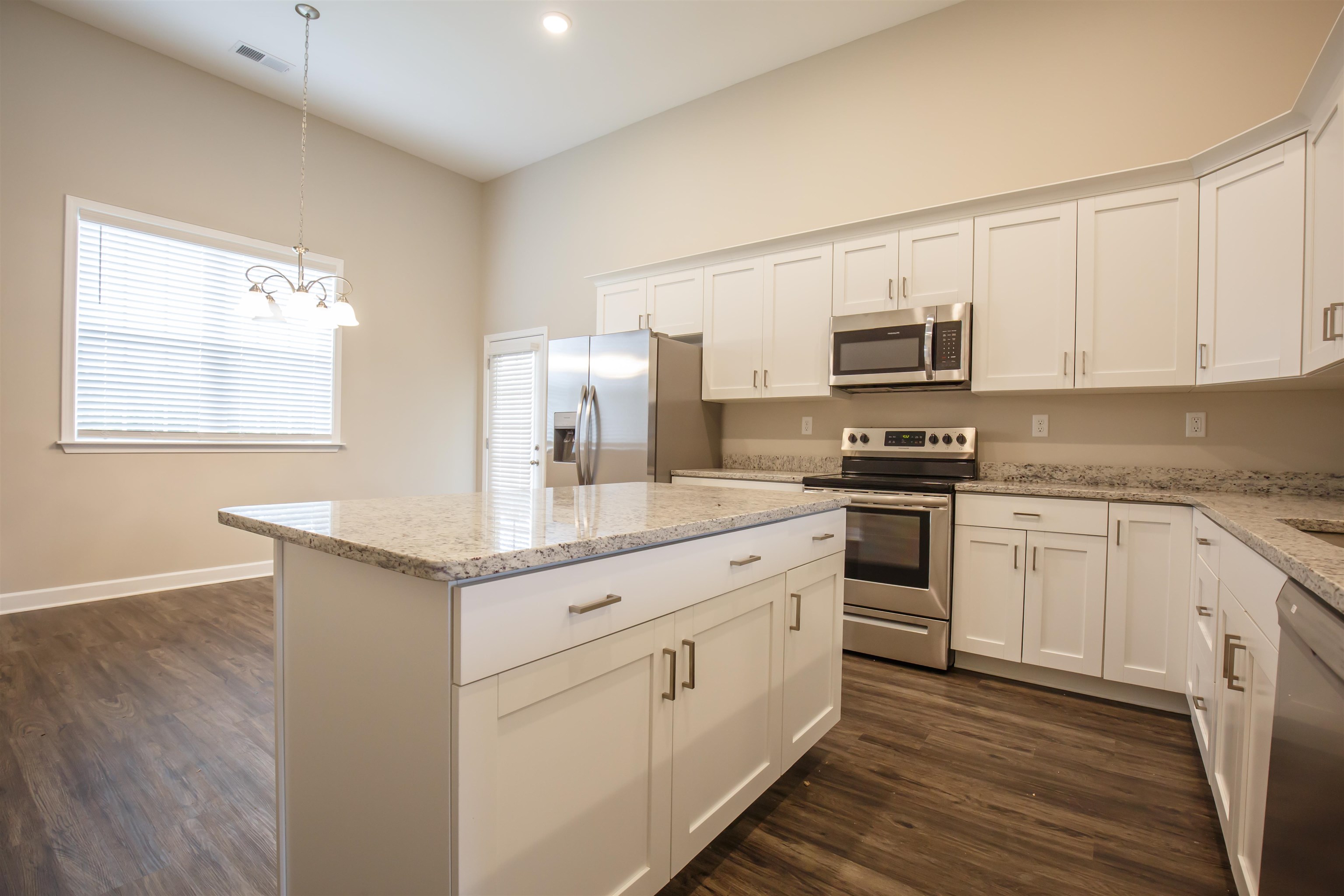 8763 Shipp Road Millington, TN 38053 - Photo 3 of 9 Kitchen with appliances with stainless steel finishes, visible vents, white cabinetry, dark wood-style floors, and a kitchen island