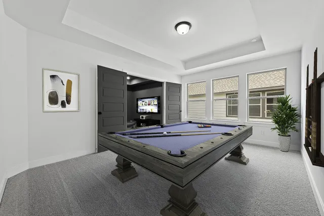 a room with pool table and windows