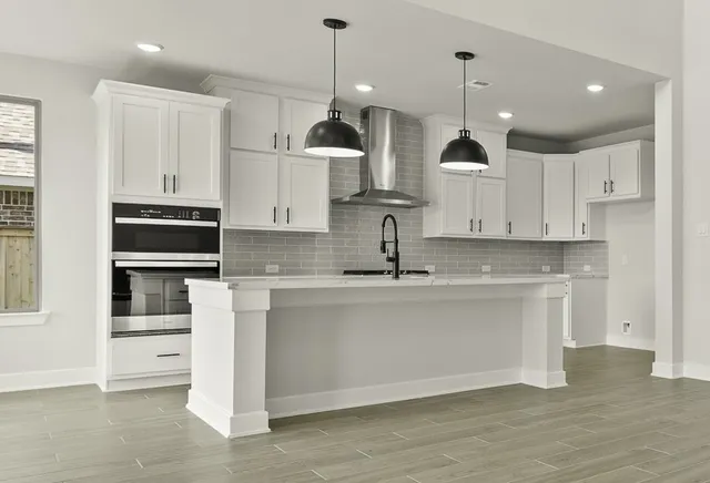 a kitchen with stainless steel appliances granite countertop a sink a stove and a refrigerator