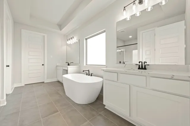 a bathroom with a double vanity sink mirror and bathtub