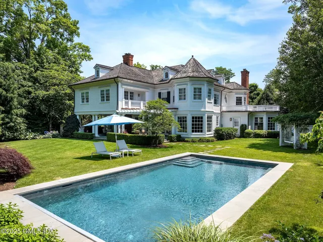 a view of an house with swimming pool and yard