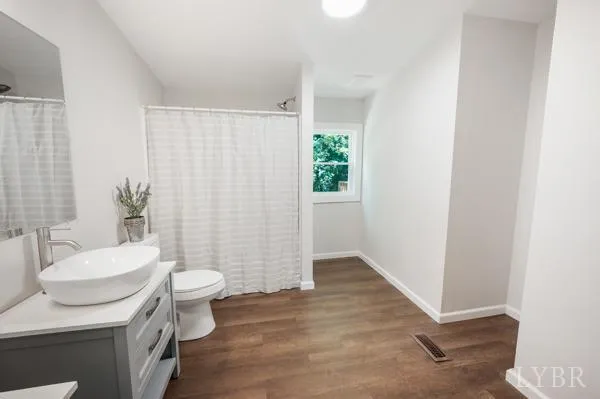 a bathroom with a sink a toilet a mirror and shower