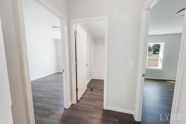 a view of a hallway with wooden floor and closet