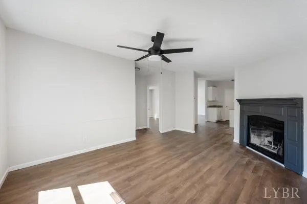 a view of empty room with wooden floor and fireplace