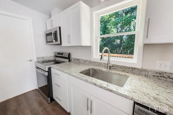 a kitchen with granite countertop a sink and a stove
