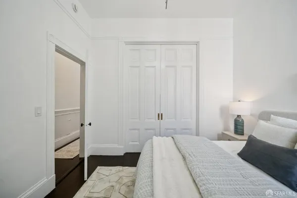 a bedroom with a bed and a flat tv screen on dresser