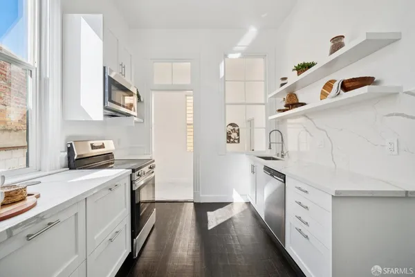 a kitchen with stainless steel appliances a refrigerator sink and microwave