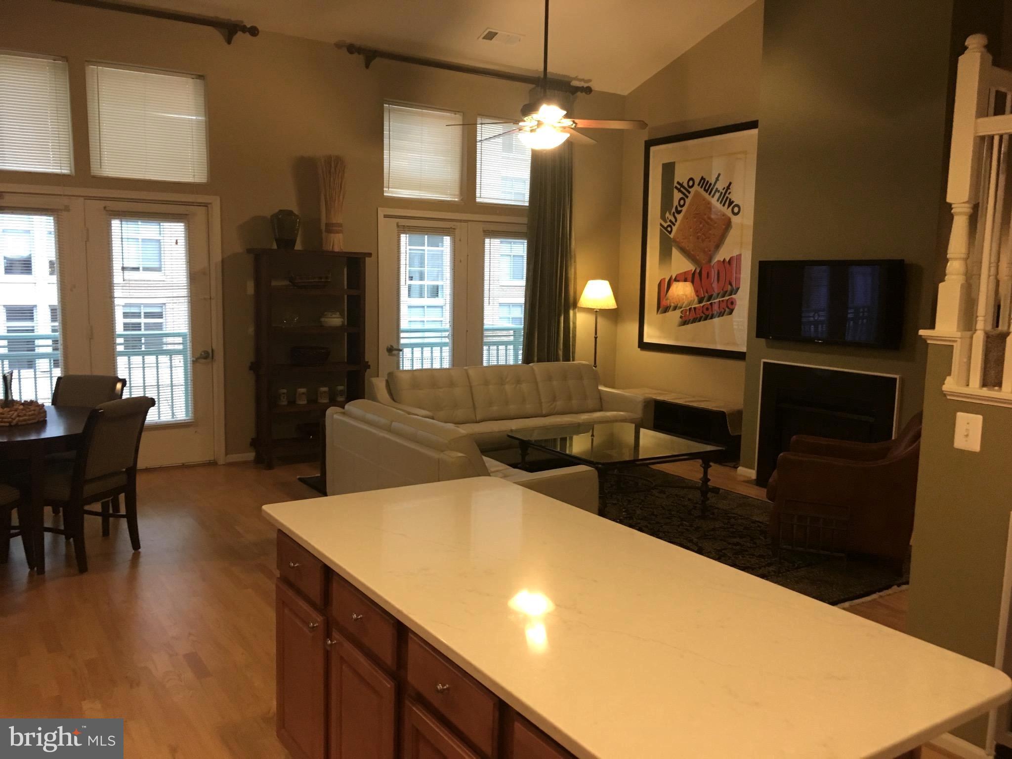 12000 Market Street, Unit 430 Reston, VA 20190 - Photo 1 of 24 a living room with stainless steel appliances furniture a fireplace and a open kitchen view