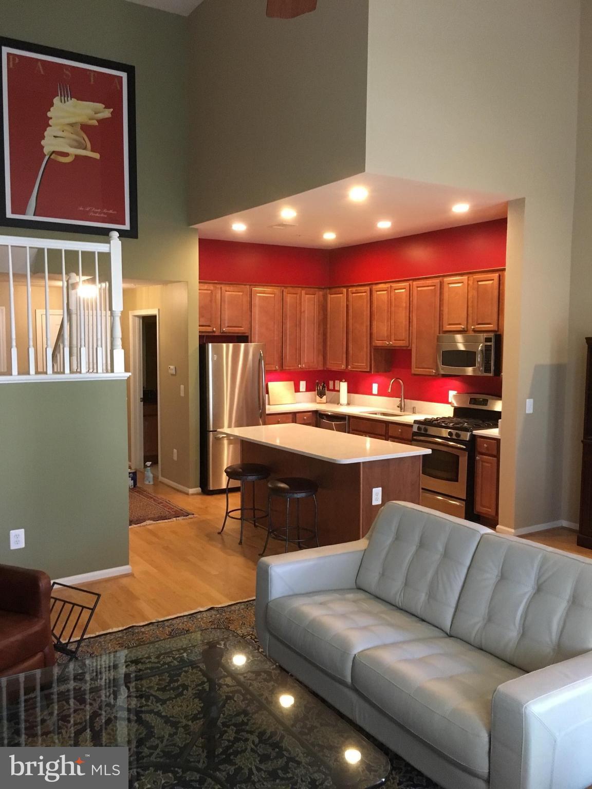 12000 Market Street, Unit 430 Reston, VA 20190 - Photo 2 of 24 a living room with stainless steel appliances kitchen island granite countertop furniture and a view of kitchen