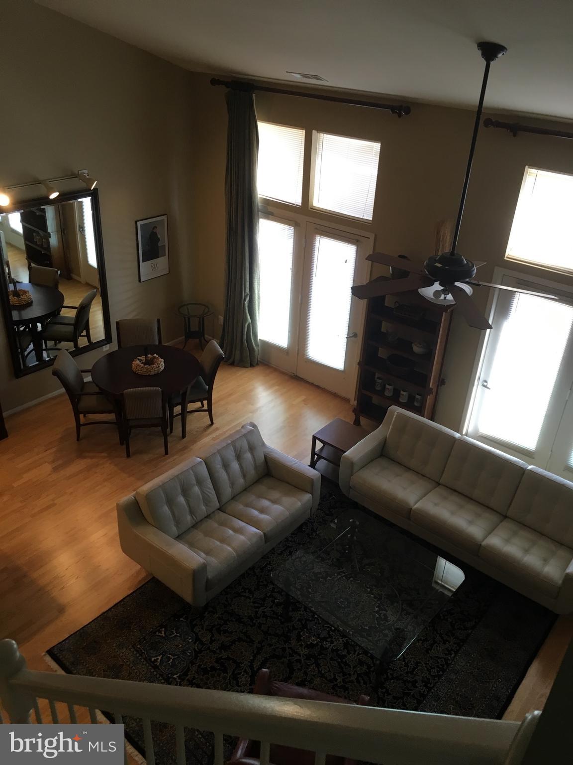12000 Market Street, Unit 430 Reston, VA 20190 - Photo 6 of 24 a living room with furniture and a flat screen tv