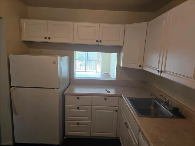 a kitchen with white cabinets and white appliances