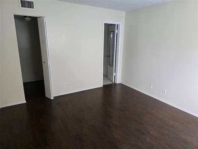an empty room with wooden floor and closet