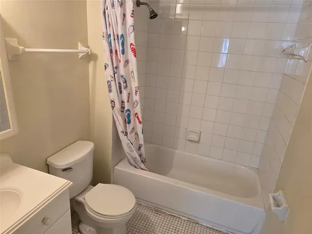 a white toilet sitting next to a bath tub and shower