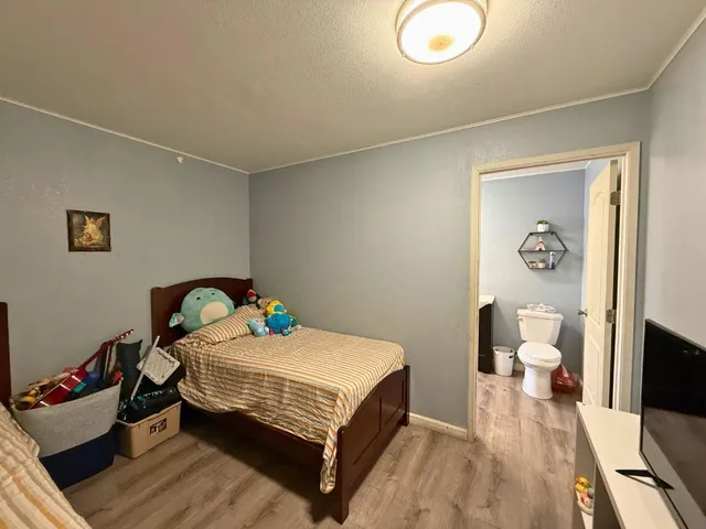 a bedroom with a bed and wooden floor